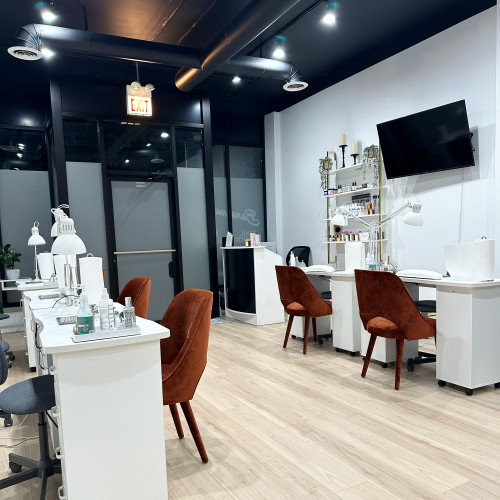 Clean, aesthetic nail salon with white tables and black ceilings