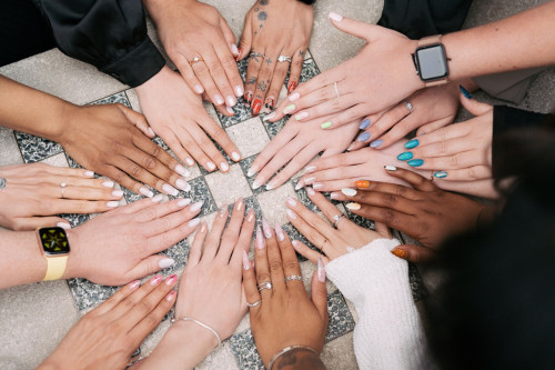 Various hands painted with gel polish in a circle